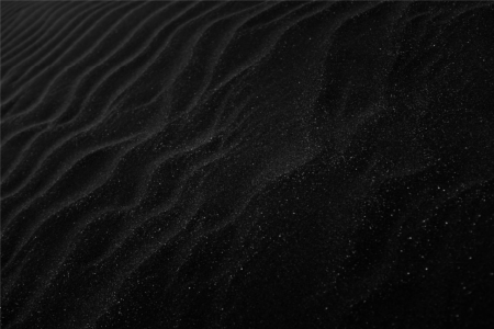 Black textured sand ripples background. Photo by Adrien Olichon on Unsplash